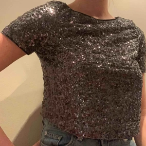  - Festtopp med paljetter. Grå/svart färg 