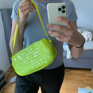 Säljer denna väska som är grön med paljetter på från Nelly som ALDRIG är använd 😊 super snygg