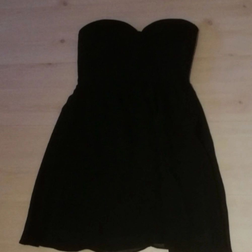 En svart kort volang klänning utan band, hjärtformad byst. I storlek 38. Använd några fåtal gånger. . Klänningar.