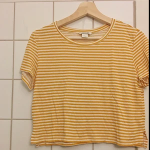  - Senapsgul & vitrandig t-shirt från monki , lite kortare i modellen. Frakt tillkommer, kan mötas i Stockholm. Betalning sker via swish.