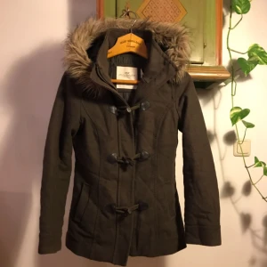  - Grön varm jacka med mysig luva (avtagbar). Hög krage som gör att man håller värmen bra. Tar emot bud om det dröjer innan jag får den såld. Skickas mot frakt eller möts upp vid Bergshamra t-bana (södra).   Katt finns i hemmet men gör såklart mitt bästa för att detta inte ska märkas.