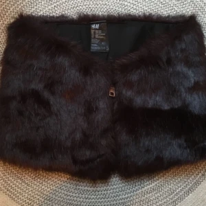  - Faux pälskrage från HM, färg djuprödbrun med guldfärgad dragkedja. Använd ca 2gr och är i väldigt fint skick!