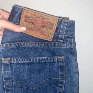 Raka Crocket jeans  - Raka högmidjade blåa jeans med 4 knappar i fram. Vintage jeans med bra skick. Storleksmässigt en 34 med W26 L30 mer bild går att få!!