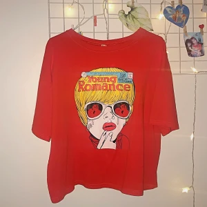 Röd Tshirt med print📍 - ❤️Super häftig röd Tshirt med ”Young Romance” print❣️😍 Frakt tillkommer 🥰 Sitter lite oversize på mig som vanligtvis är S