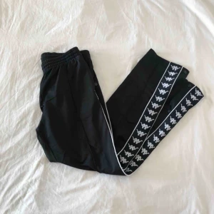  - KAPPA popper pants i svart. sparsamt använda, så bra skick! knappar hela vägen upp längs sidan. frakt tillkommer! kolla mina andra annonser så kan jag skicka flera saker samtidigt om det är av intresse 😌⚡️