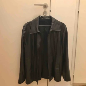  - skinnjacka köpt i spanien! vet inte om det är äkta skinn/läder eller imitation. köptes för 200kr men har tyvärr aldrig blivit använd efter :( fraktar inte men möts upp i stockholm!  (jackan är svart men ser brun ut pga den gula lampan haha)