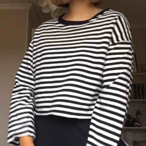  - En randig tröja från H&M i svart och vit, med en svart krage. Inte använd särskilt mycket och är lite stor i storleken. Säg till om fler bilder önskas!