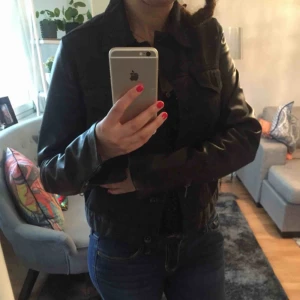  - Tiger of Sweden jeans jacka i svart färg , armarna är i läder . 