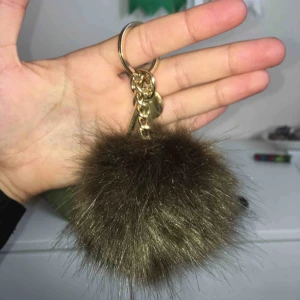  - En militärgrön fejk päls nyckelring, har aldrig använt denna. Med guld kedja, en dublon och ett knäppe