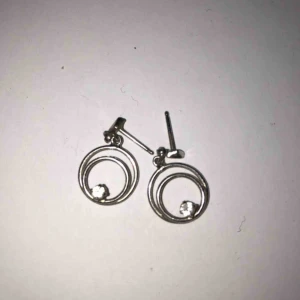  - Silvriga örhängen med en kristall. Aldrig använda. Köparen betalar frakten