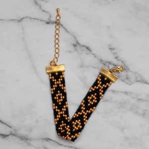 Armband  - Pärlat armband i svart och guld, passar de flesta handleder. Obs! De är inte orangea som på bilden, Photoshop ändrar färgerna för mig 🙃 11:- i frakt, fri frakt vid köp över 100:-.