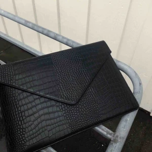  - Crocodile-print i veganskt läder som även är vattenavvisande med extra fack på baksidan. 🖤❤️Innermått- längd 33 cm bredd 23cm djup 1,8 cm  Kolla gärna vår instagram-@weeklyaccessoriesuf 