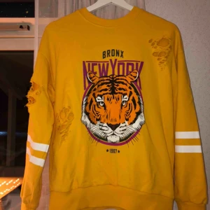 Tiger tröja  - Skön sweatshirt från Gina Tricot. Köpt för 300 säljer för 130kr. Hål vid armhålan, armen och magen som ska vara där.  Använd få ggr