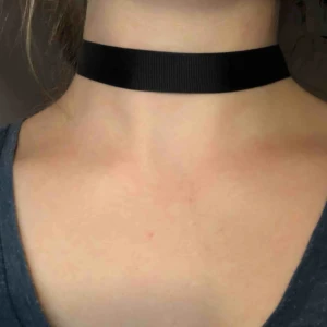  - Choker halsband i svart med silver detaljer. Den kan som längst bli 37 cm och som kortast 29 cm. Den är 2 cm tjock. Köparen betalar frakten.
