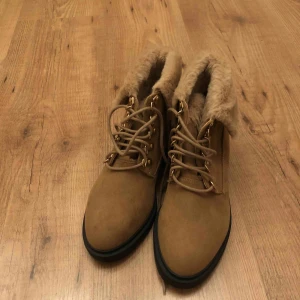  - Ljusbruna kängor med en liten klack.