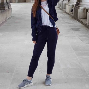  - Marinblå joggers med röd/vita revär på sidan i stretchigt material. Har används en del, men finns inga slitningar. Är väldigt bekväma. Säljer då jag inte finner mig använda dem längre. Frakten ingår!