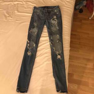 Blå jeans från Hollister med slitningar på framsidan