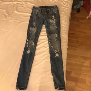  - Blå jeans från Hollister med slitningar på framsidan
