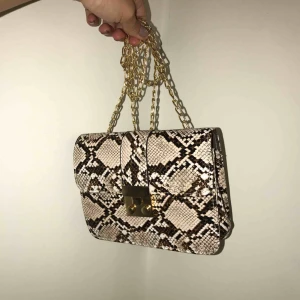  - Helt ny (i förpackning). Supersnygg väska i fake mönstrat ormskinn! Frakt tillkommer! 