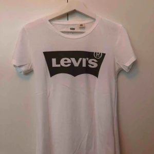  - Säljer denna klassiska vita T-shirt med grå logga från Levi’s. Storlek XS.