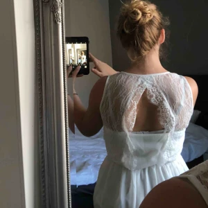  - Vit tröja med öppning i ryggen. Klädd med spets vid ryggen