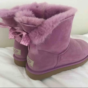  - Ett par rosa låga uggs me rosetter där bak, köptes på NK i Stockholm för 1800 kr, säljs för 400 kr, använd ett fåtal gånger men endast inomhus💕💕