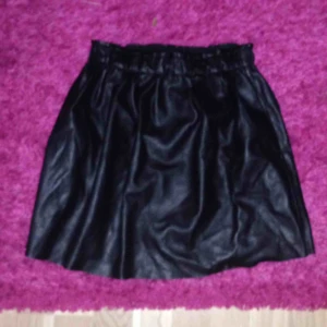 - Kort skinnkjol i skatermodell,rynkad upptill.   OBS! Säljer endast till den som kan hämta upp plagget i Helsingborg, skickar inget!