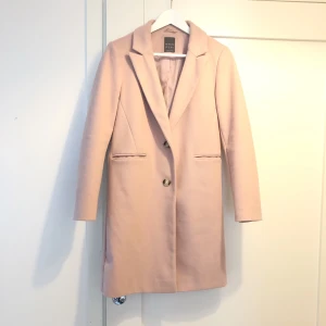 Snygg höst kappa i stl 32 funkar till en 34 med.  - En gammalrosa knälång kappa stl 32-34. Fin till höstiga 🍁 dagar eller milda vinterdagar. Använd endast 2 gånger. Min dotter har växt ur den. Köptes på Primark i London Januari i år 2020. Superfin. 