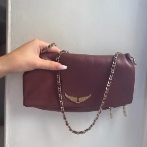 Zadig voltaire väska - En Zadig Voltaire väska i vinröd färg med guld detaljer