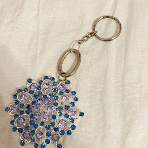 Nyckelring med en blomma - Handgjord och OANVÄND nyckelring)) köp gärna. En blå blomma med stenar (Saknar inga stenar) köp gärna!!