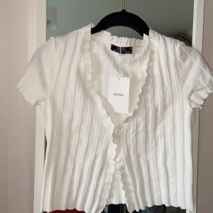 Vit v-ringad Kofta  - En vit v-ringad kofta med knappar från Bershka. Liten i storleken kan bäras som S. Aldrig använd prislapp kvar. Nypris (159kr) frakt ingår 