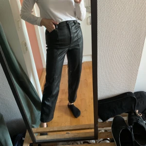 Skinbyxor  - Svarta skinbyxor (fake skin)  från H&M med synliga sömmar i storlek 34. Sparsamt använda och i mycket bra skick. Bara använt ett fåtal gånger🖤Jag är 159 cm lång. 100 kr + frakt 