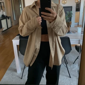 Beige skjorta  - Säljer den här fina beiga skjortan som inte kommer till användning. Inköpt på Gina Tricot! Sitter oversize det på mig som har 36. 