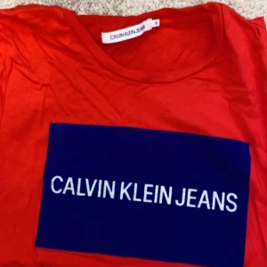 T-shirt Calvin Klein jeans  - Röd t-shirt från ck, mycket fint skick använt typ 1 gång. Fick i julklapp men inte fått användning för den. Reflex på loggan🤪