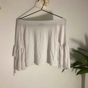  - Vit off shoulder-topp med knytning i ärmarna. Aldrig använd 