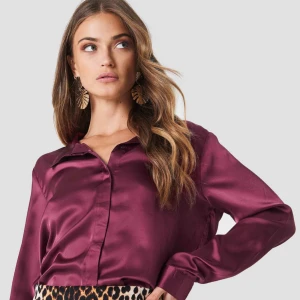  - Vinröd satin skjorta från Ruth&circle. Ett par trådar har lossnat (sista bilden) där fram i höjd med nedersta knappen, därav priset. (Frakt tillkommer)