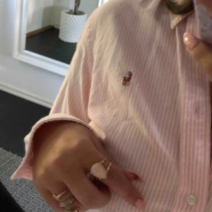  - Eventuell frakt ingår i priset. Vit, rosa randig skjorta som tyvärr aldrig kommit till användning