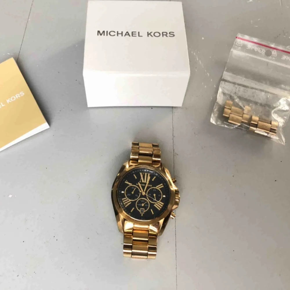 Lyxig klocka från Michael Kors ”Bradshaw - MK5739”. Originalbox, äkthetsbevis (?) samt extra spännen medföljer. Kvitto finns. Nypris idag: 2700kr. Klockan är i bra skick, med undantag för en liten ”bubbla” i glaset. Budgivning! . Accessoarer.