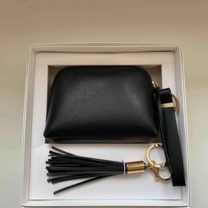  - Oanvänd Clutch med handledsrem från Åhléns