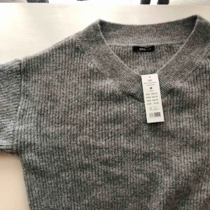  - Grå stickad tröja från Gina Tricot. Helt oanvänd, lappen kvar. Ordinarie pris: 399 kr. 