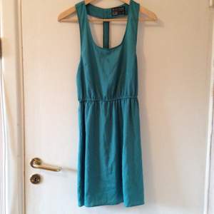 Turquoise dress, zipper in the back (not possible to zip-up). Never used. 100% polyester.