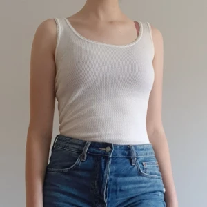 Vit tanktop - Vit tanktop med sött kant. Ett väldigt bra basplagg, men fortfarande supergulligt i sig med den unika väven och kanten. Är i ca storlek S-M. Är väldigt stretchig, så passar de flesta. Säljer för 39kr exklusive frakt (22kr). Dock ingår alltid gratis frakt vid köp över 300kr. Skriv i dm vid intresse eller för frågor! 