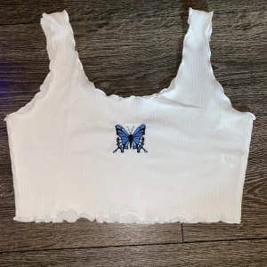 Fjärils linne xs - Ett vitt linne med en blå fjäril på. Aldrig använd, köpt för ca en månad sen. Linnet är ifrån Shein, strl xs. Den sitter lite löst på mig med små bröst så det skulle passa perfekt för dom med större storlekar med!