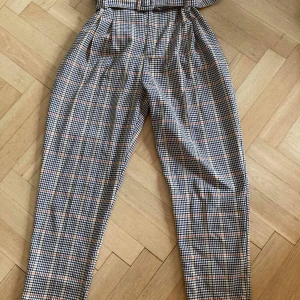 Rutiga paperbag byxor Bershka, strl 36 - Säljer ett par rutiga paperbag byxor från Bershka. Köptes för två år sedan men har knappt kommit till användning. Byxorna är högmidjade men lite kortare i längden (jag är 168 cm). Säljs för 100 kr och köparen står för frakt (65kr).