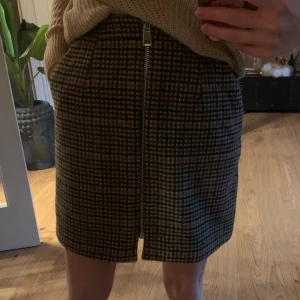 Rutig kjol - Figurnära kjol i XS. Dragkedja fram, lite tjockare tyg och har fickor. Oanvänd.