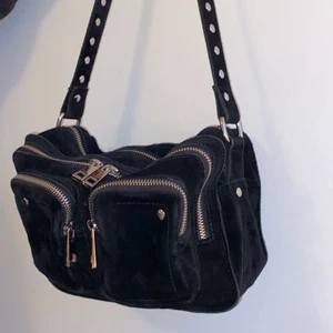 Nunoo Väska Svart - Inte så använd jättefin Nunoo väska i svart köpt från nelly.com🌟 Massor med utrymme så den passar perfekt som vardagsväska🤩🌈Köparen väljer själv mellan icke spårbar frakt för 48kr eller spårbar frakt för 66kr💕