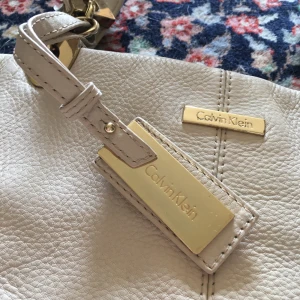 CALVIN KLEIN skinnväska - Väska i vitt äkta skinn från Calvin Klein. Toppenskick! Köpt på tradera men aldrig använd. Köparen betalar frakt! 