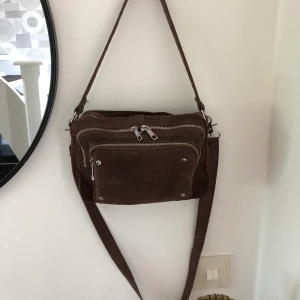 Noella bag - Brun snygg handväska  Noella Cali Bag Färg brun 100% imitationsläder Storlek 15x25x7 Crossover väska  Avtagbart axelband som är reglerbart  Nypris 649kr Mitt pris 300kr pp 63kr