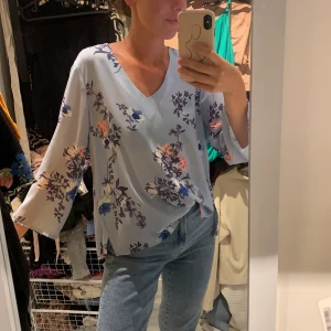 Blommig topp stl 34 - Ljusblå blommig topp i stl 34. Frakt tillkommer.