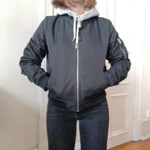  - Svart bomberjacka från carlings märke STAY. Ljusgrått foder med innerficka och en på armen. Storlek 38 men funkar med hoodie under